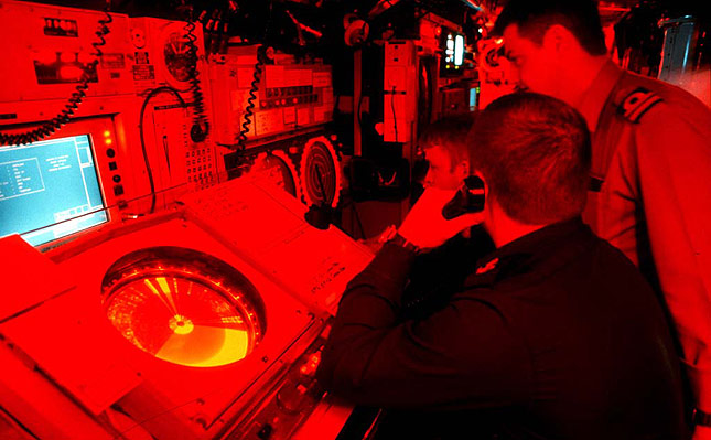 HMS TRIUMPH control room under red light.